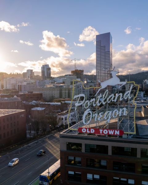 city view of downtown area with rolling hills in the background as the sun sets