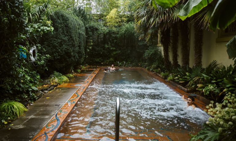 a man enjoying a warm water, outdoor pool