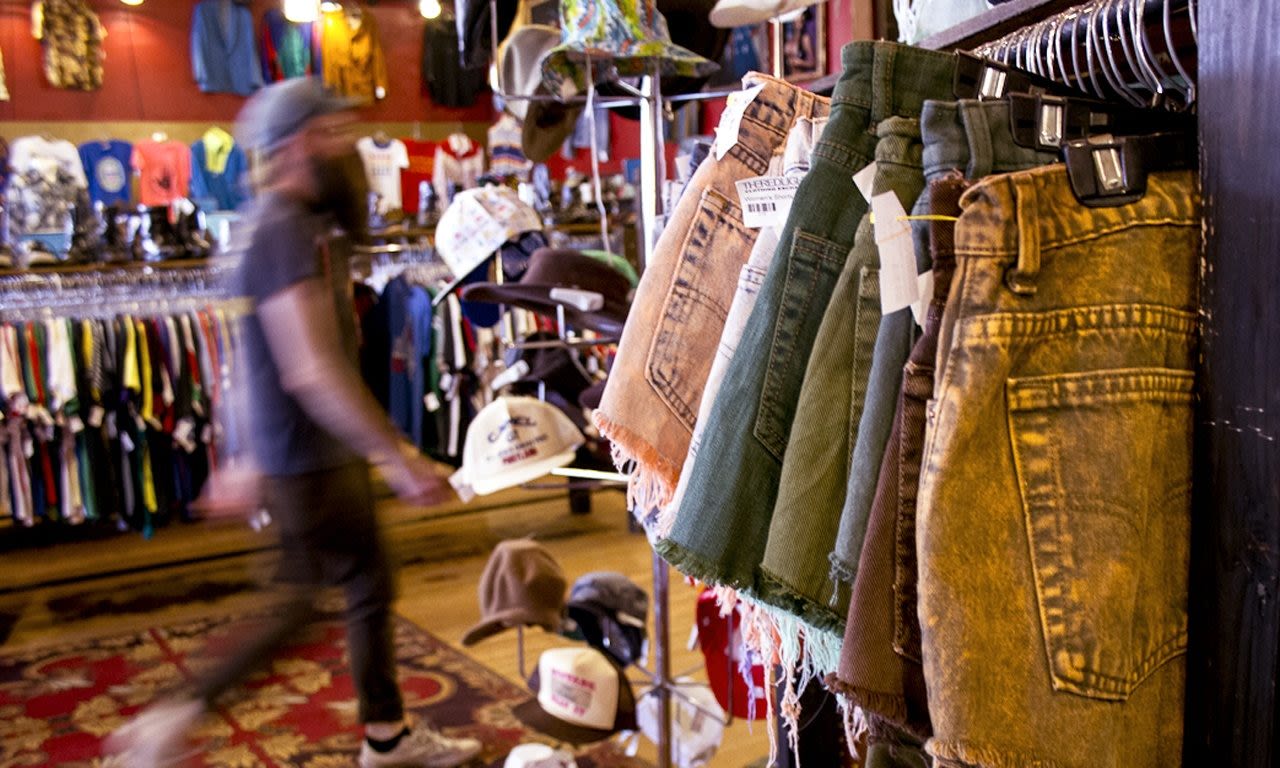 racks of clothing and hats on display at the Red Light Clothing Exchange