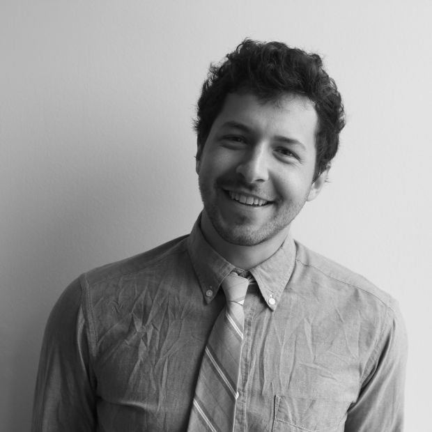 black and white photo of a smiling man in a shirt and tie