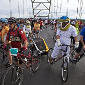 a crowd of bikers riding across a bridge during Bridge Pedal