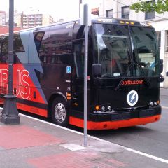 a black and red passenger bus at rest on a downtown street