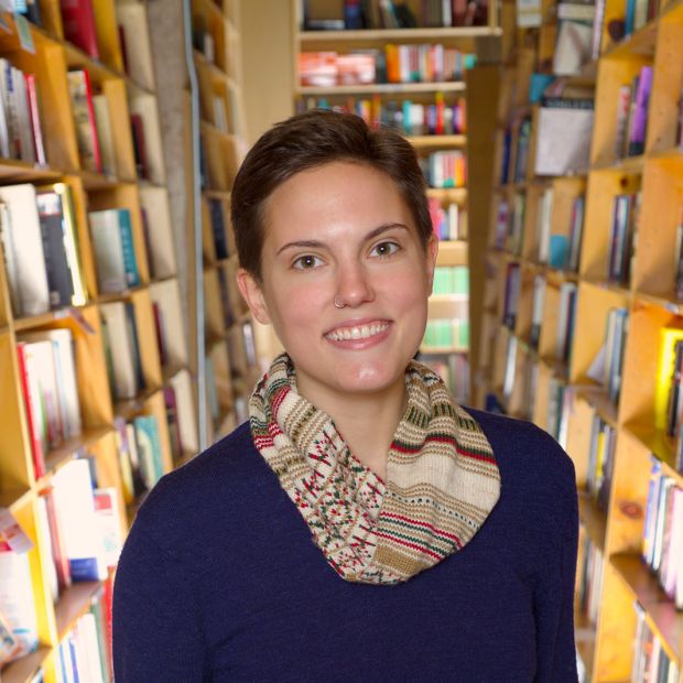 person standing between bookshelves at a bookstore