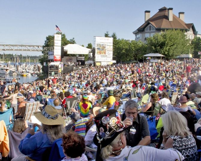 a massive crowd of people enjoying music on the waterfront