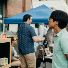 person looks at artwork on display at an arts walk
