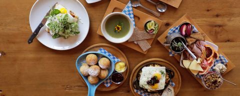different plates of traditional Nordic brunch items arranged on a wooden table