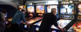 people playing pinball machines