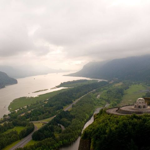A magnificent view up the Columbia River Gorge, the golden light of a setting sun hitting the cliffs below the Vista house.