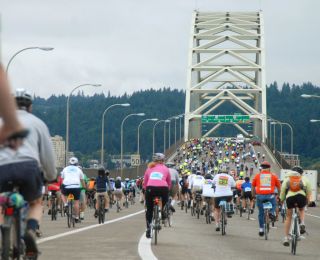 many cyclists crossing a bridge