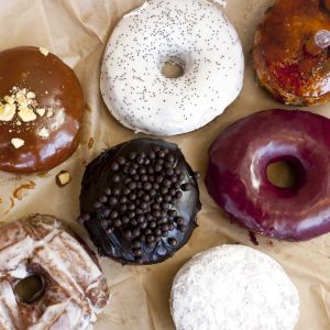 seven gourmet donuts on parchment paper