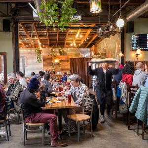 people seated at tables eating inside a brewery