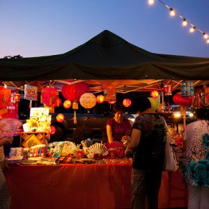 person selling products under a tent at an outdoor market