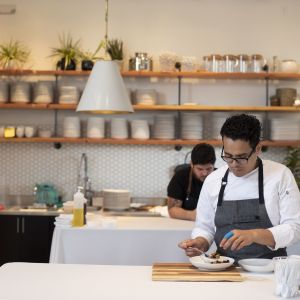 A chef plates some food in a kitchen