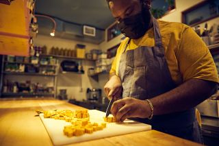 A chef chops squash in a restaurant kitchen