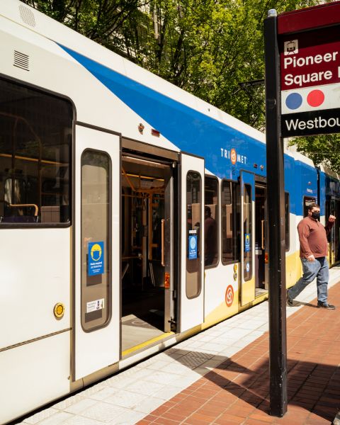 a person gets off the light rail train at the Pioneer Square stop with its iconic red brick walkway