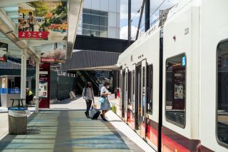 two people board a MAX light rail train at Portland International Airport (PDX)