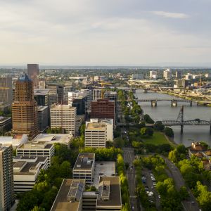 aerial view of a city\'s downtown with many bridges over the river that divides the city\'s neighborhoods