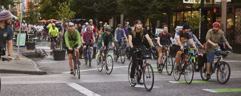 a group of cyclists ride together ona protected street