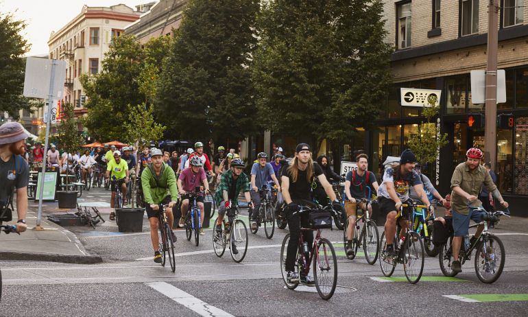 a group of cyclists ride together ona protected street