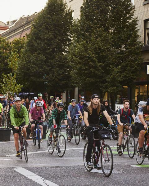 a group of cyclists ride together ona protected street