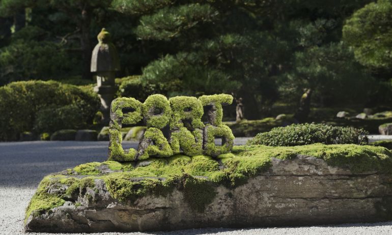 stylized photo showing PORTLAND spelled out in stacked mossy rocks
