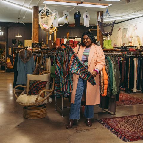 a woman looks at a sweater at Artifact PDX