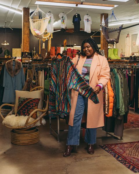 a woman looks at a sweater at Artifact PDX