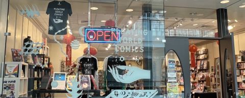 comic book store front showing shelves, books and t-shirts inside
