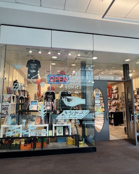 comic book store front showing shelves, books and t-shirts inside