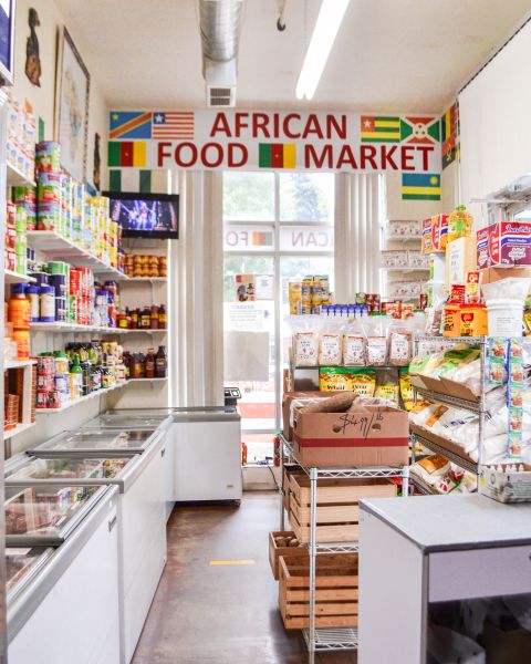 a sunlit and orderly store is filled with food items