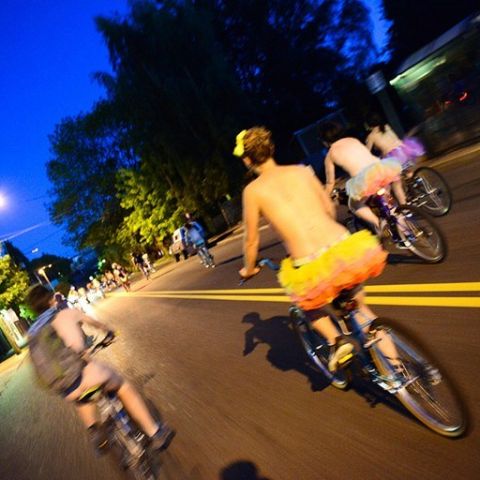 people on bikes at night wearing very little clothing