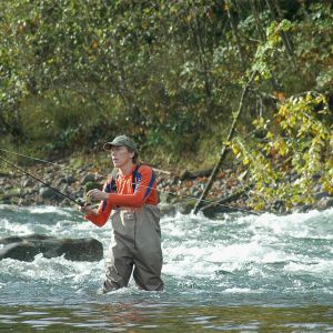a fisherman flyfishing in a river