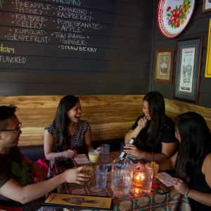 A foursome laughing over drinks at the Whiskey Soda Lounge.