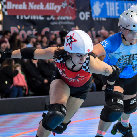 a roller derby skater with a star on their helmet passes another skater